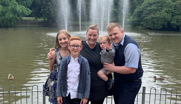 Smiling family standing by a lake