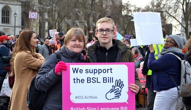 Daniel (16) with his mum at the BSL rally holding a sign that reads 'We support the BSL Bill'
