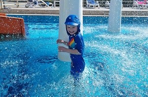 Kenzie (4) wears a protective hat while in a swimming pool