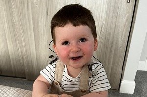 A baby boy wearing a cochlear implant