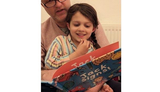 Dad and his son reading 'Jack Signs' book together