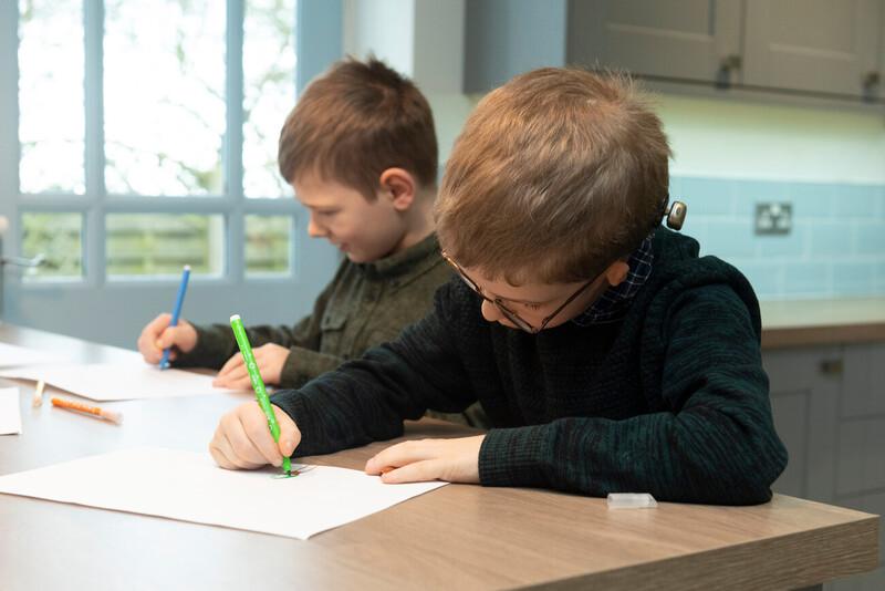 Two children writing on a table