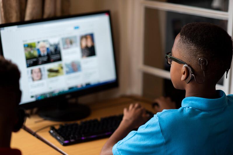Young child sat at a desk looking at a computer screen