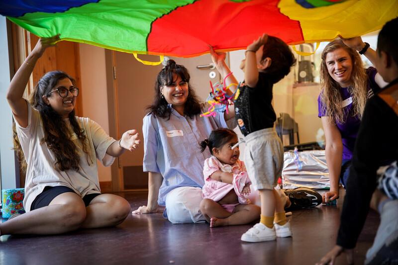 A child playing under a parachute in a school