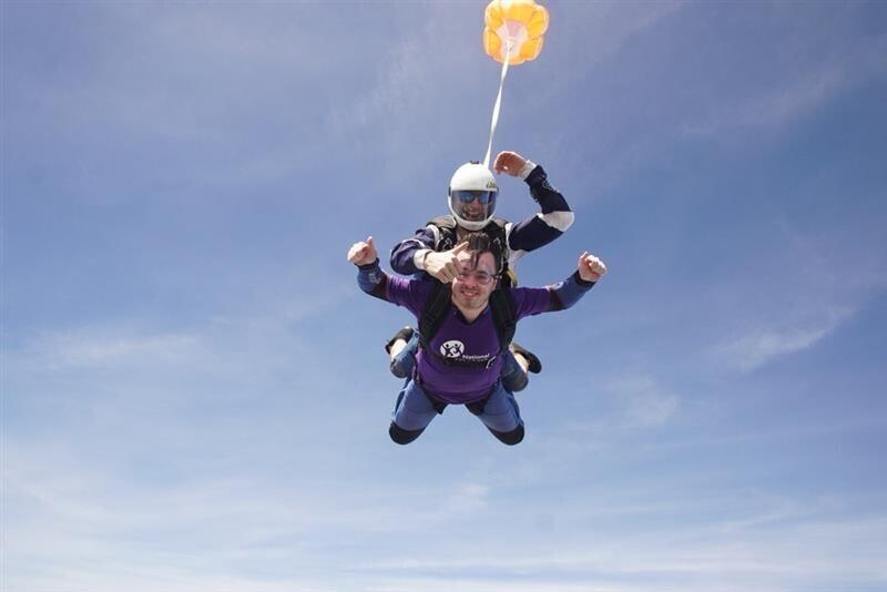 Two people skydiving and smiling