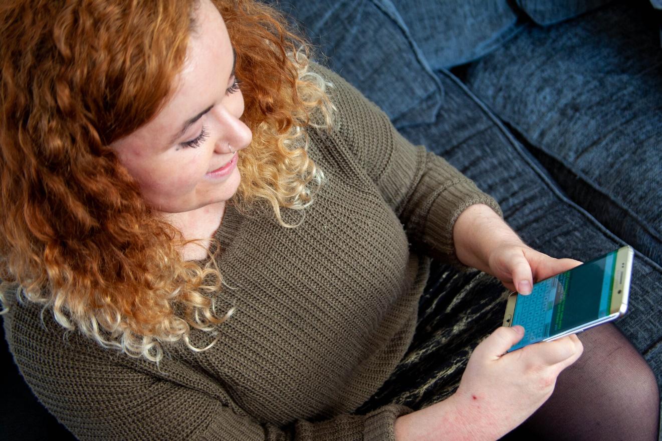 Young woman using the Relay UK app on her phone