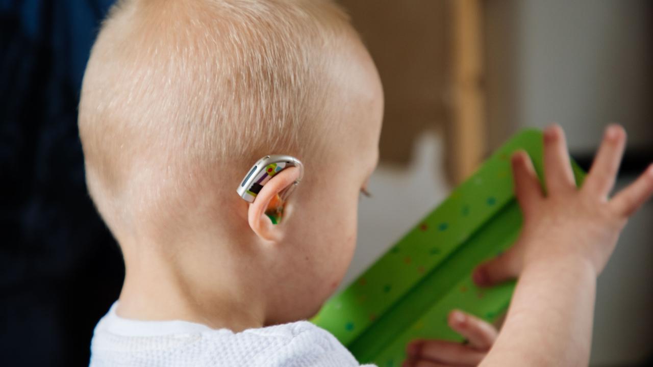 Baby wearing behind-the-ear hearing aids