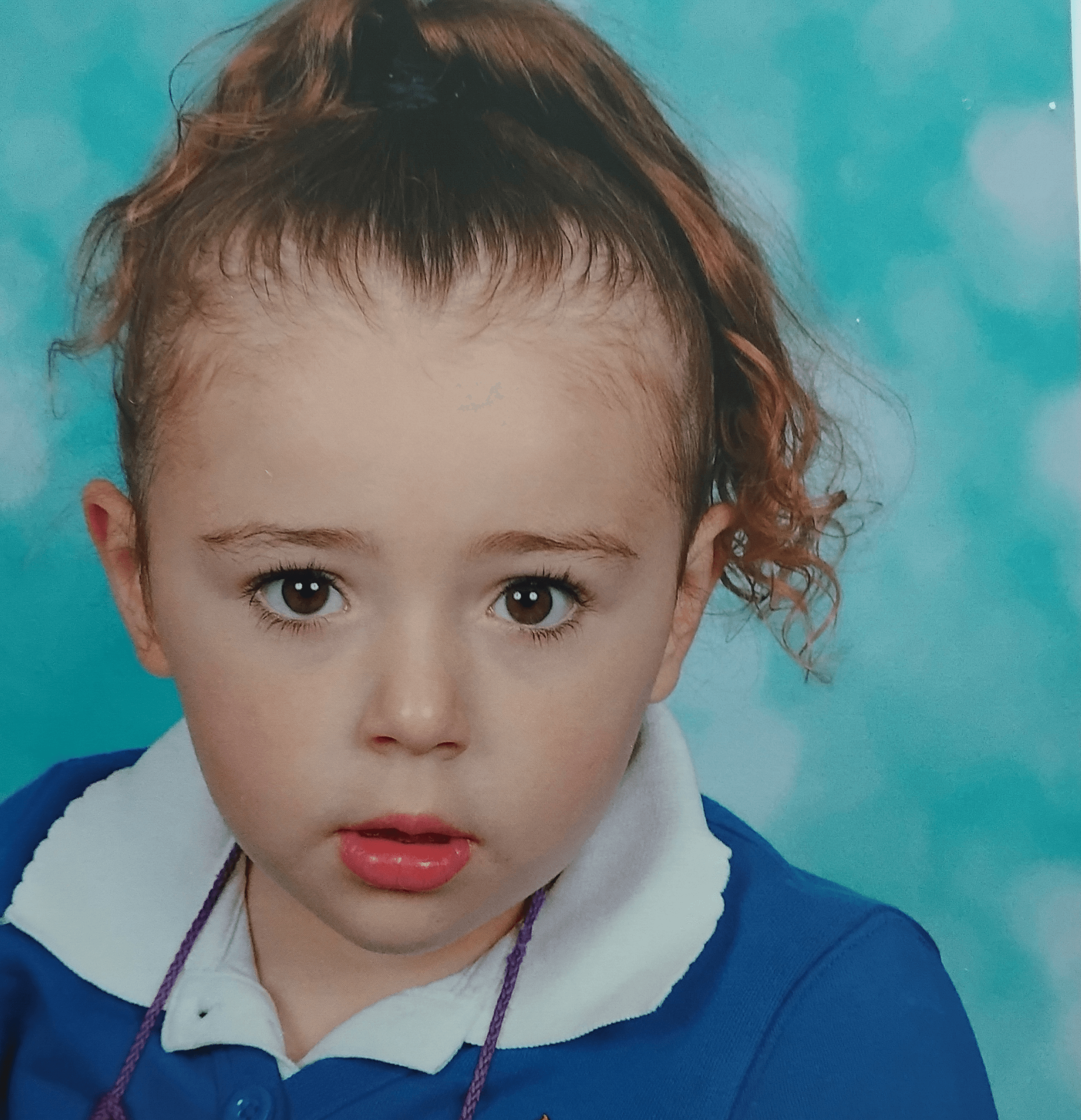 Ava looking at the camera in a school photo.