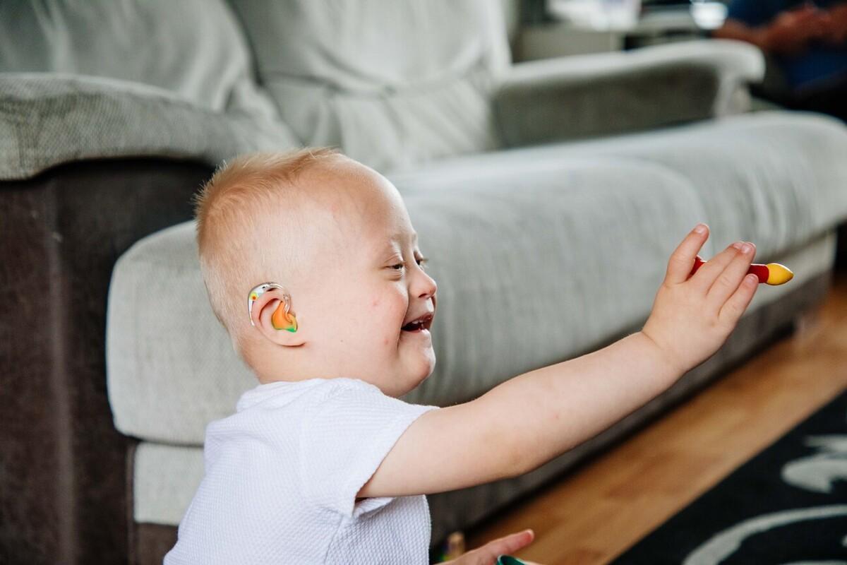 A child with Down's syndrome plays on the floor
