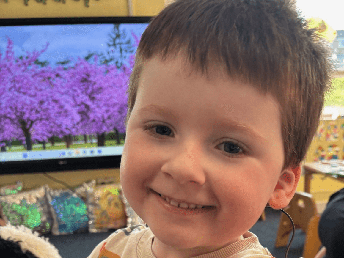A toddler smiling in a nursery setting