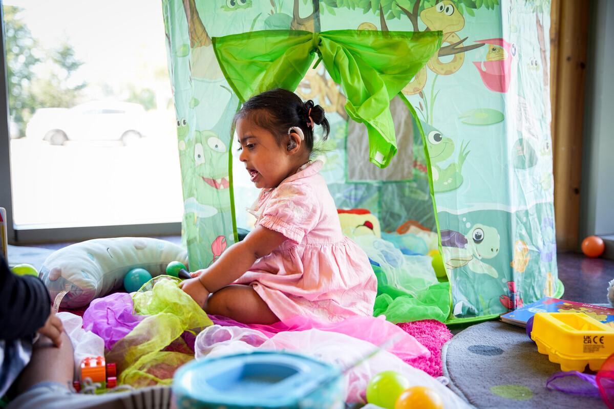 A girl with Down's syndrome plays in a play centre.