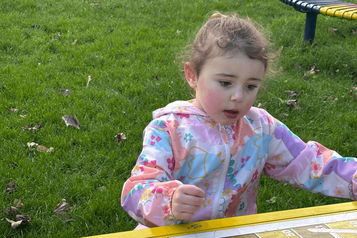 Young girl sitting at a table outside