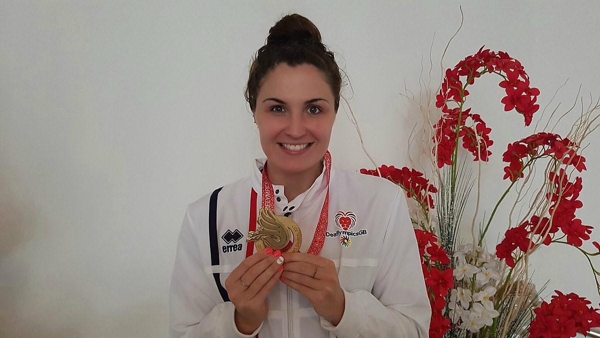 Danii, a Deaflympics swim champion, holding an award medal