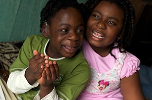 Two deaf young children smiling at the camera