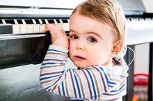 Deaf toddler with two hands on a piano 