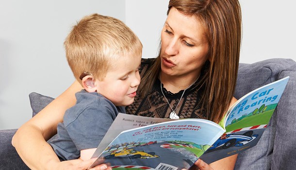 Deaf child and parent reading a book together