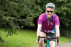 Cyclist wearing purple National Deaf Children's Society cycling jersey