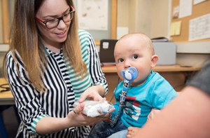 An audiologist monitors a baby's hearing.