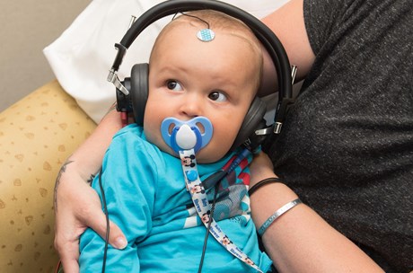 Baby having a hearing test wearing headphones 