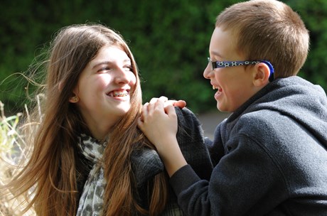 A teenager smiles at her brother.