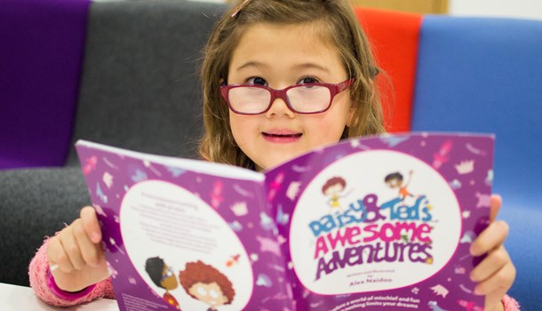A girl reads 'Daisy and Ted's Awesome Adventures'.