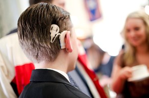 The back of a boy's head who is wearing a cochlear implant. 