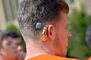 The back of a young man's head and his cochlear implant