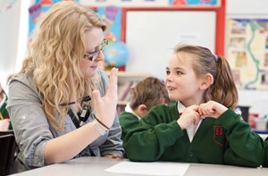 Teacher and pupil communicating in a classroom
