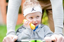 A child wearing a headband using a toy phone