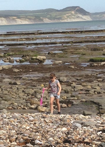 Deaf child on the beach with a spade