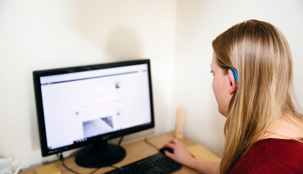 Woman with a hearing aid using a computer