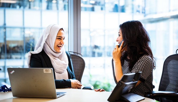 Mariam (25) laughing with a colleague in an office