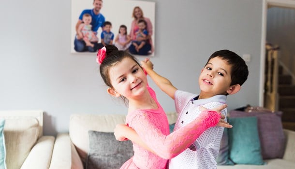A deaf girl dressed as a ballerina dancing with her brother.