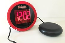 Red and black Geemarc Wake 'n' Shake Dynamite alarm clock with vibrating pad.