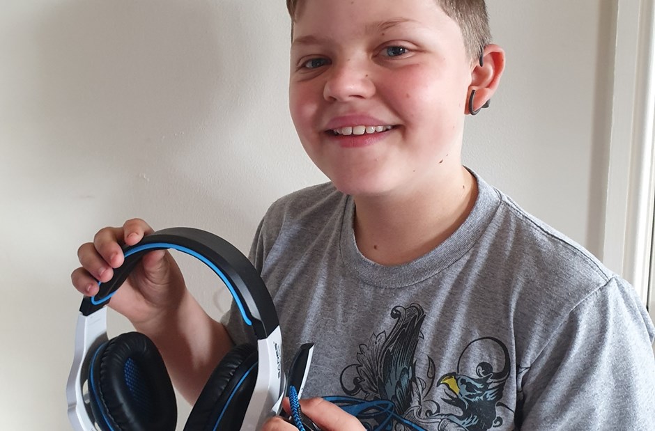 A deaf boy holding headphones