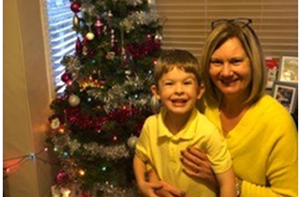 Maria and her grandson Oliver in front of a Christmas tree