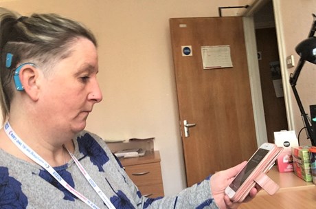 Penny, a deaf community matron, looks at her phone. 