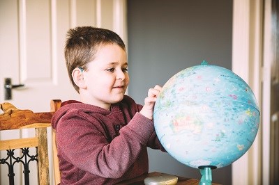 Elijah looking at a globe.
