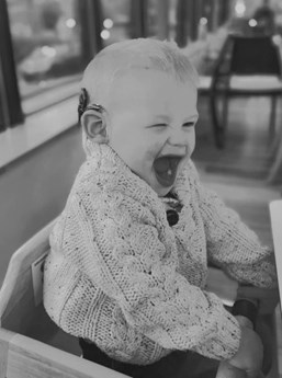 Black and white photo of a little boy laughing