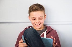 A child looks at his tablet device. 