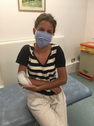 Girl in face mask with arm in plaster