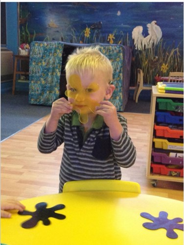 Little boy sitting at a colourful table at nursery