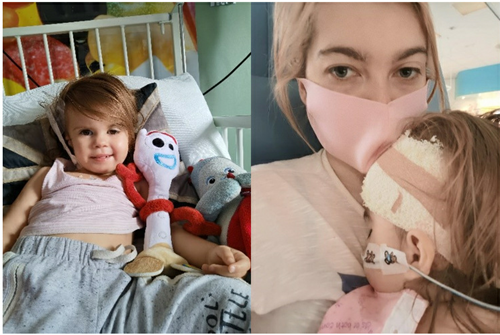 Girl in hospital bed with toys next to mum and daughter