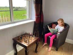 Little girl reading a copy of The Quest for the Cockle Implant