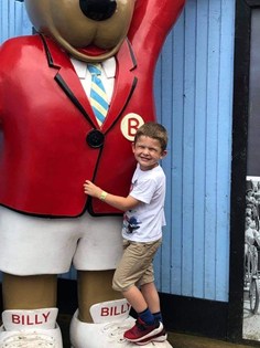 Boy hugging bear statue