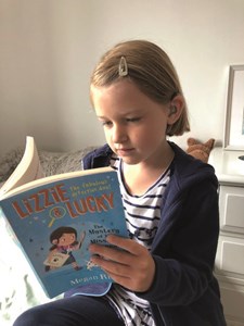 Elodie (6) reads a copy of Lizzie and Lucky