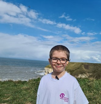 Boy standing on a cliff with NDCS T shirt