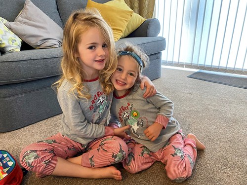 Two sisters in PJs sitting on the floor