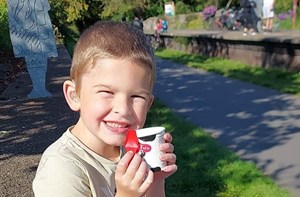 Boy sitting on wall eating ice cream