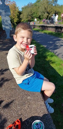 Boy sitting on wall with ice cream